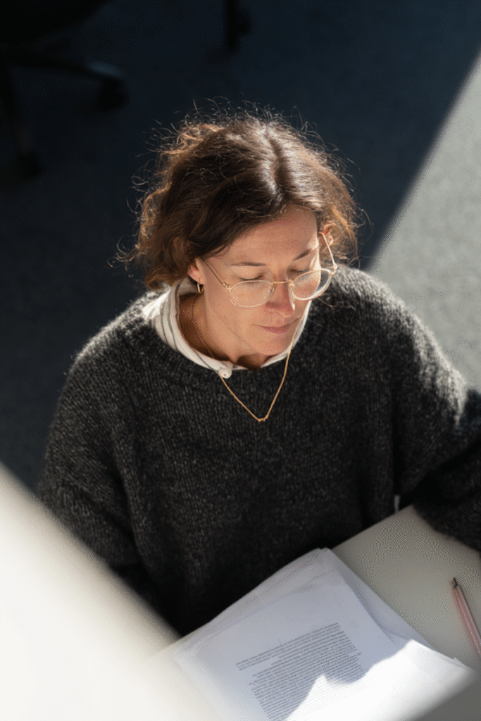 Woman reading a business plan document, focusing on small business tips and strategies